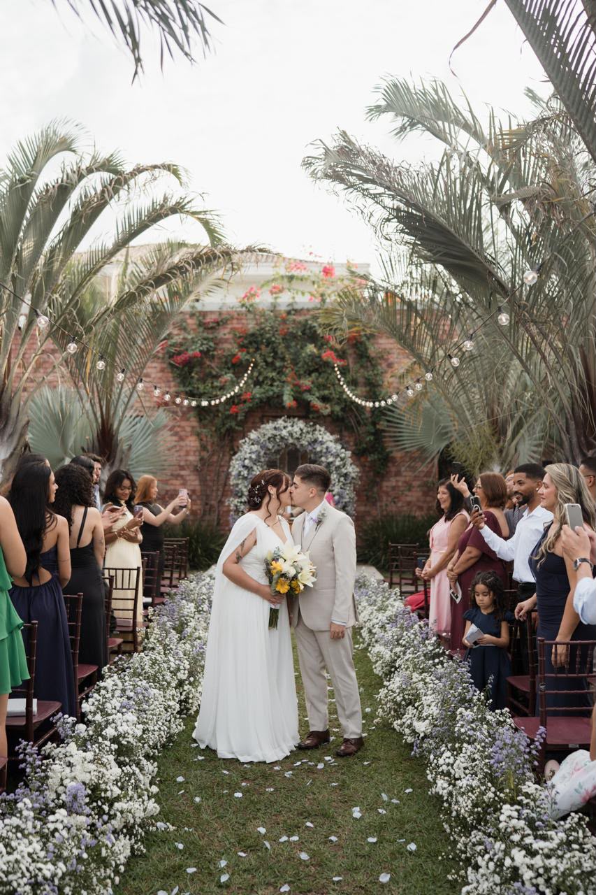 Casal em cerimônia com caminho floral